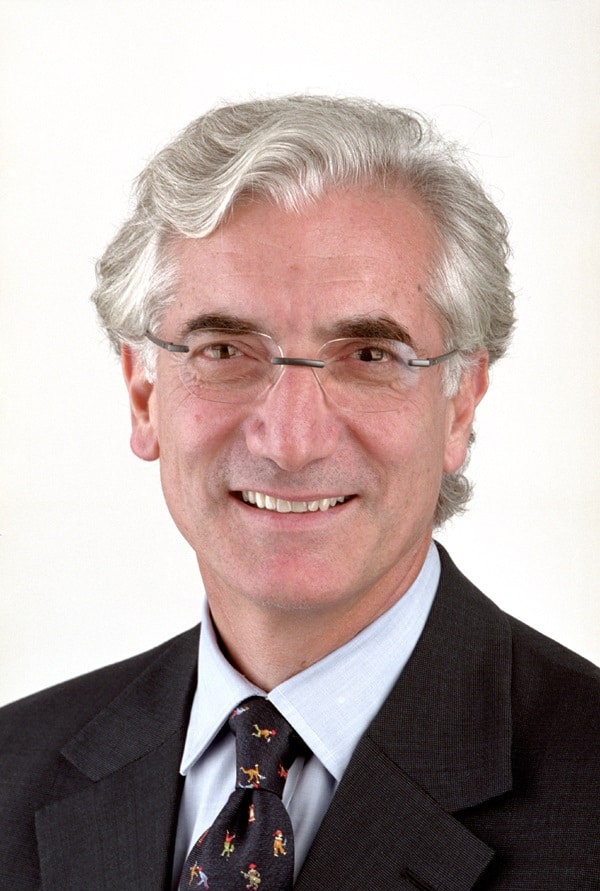 Headshot of Sir Ronald Cohen wearing glasses and a suit and tie.